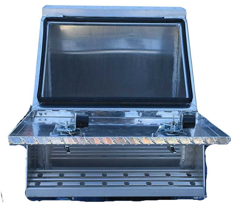 Durable aluminum step box measuring 23 inches deep, 28 inches high, and 24 inches wide, weighing 51 pounds. Equipped with welded steps featuring punched plates, T-lock with nylon roller, and rubber weather seal. Mounting brackets sold separately